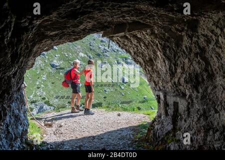 Pass von Valparole, in den Bergen, in der Provinz Belluno, in Venetien, Italien, Europa. Wanderer am Eingang des Gioinger Stollens am Hexenstein Stockfoto