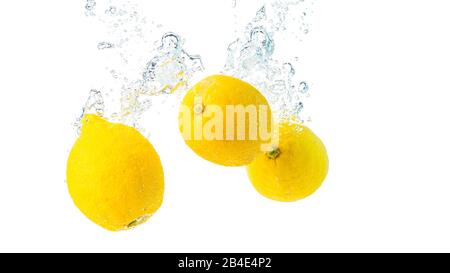 Zitronen spritzen in Wasser und sinken auf weißem Hintergrund. Stockfoto