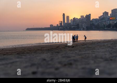 Indien, Maharashtra, Mumbai, Menschen am Chowpatty Beach, Sonnenuntergang, Skyline, Stockfoto