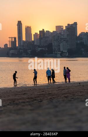 Indien, Maharashtra, Mumbai, Menschen am Chowpatty Beach, Sonnenuntergang, Skyline, Stockfoto