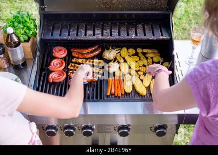 Zwei Frauen grillen im Garten, grillen Stockfoto