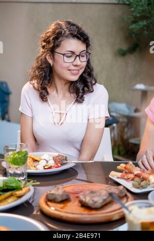 Junge Frau am Tisch, Grill Stockfoto