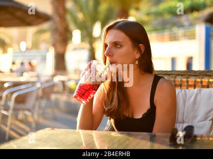 Junge Frau trinkt Sangria in einer Strandbar, Calheta, Madeira Island, Portugal Stockfoto