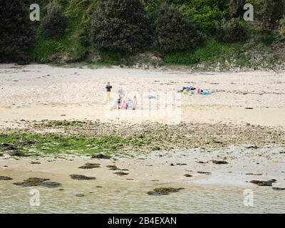 Ein Familiennachmittler am Strand von Capusins in Audierne in der Bretagne. Die Kinder positionieren sich für ein Erinnungsfoto. Stockfoto