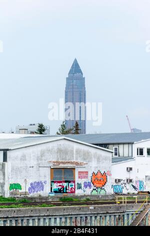 Deutschland, Hessen, Frankfurt, der Messturm hinter einem Geschäftshaus am Main. Stockfoto