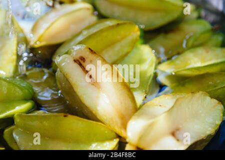 Nahaufnahme von frischen organischen Sternfrüchten (Averrhoa carambola), auch Carambola genannt, die verzehrfertig gewaschen wurden, im Freien Stockfoto