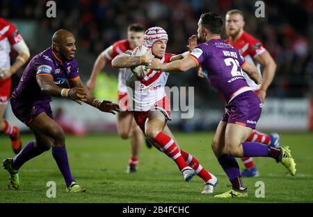 Theo Fages der Heiligen St. Helens wird von Michael Lawrence (links) und Tom Holmes (rechts) von Huddersfield Giants während des Betfred Super League Spiels im Totally Wicked Stadium, St Helens, angepackt. Stockfoto