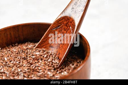 Gemeinsame Flachs Lein - Linum usitatissimum - kleine hölzerne Schüssel, closeup auf Holzlöffel in Haufen Samen. Stockfoto