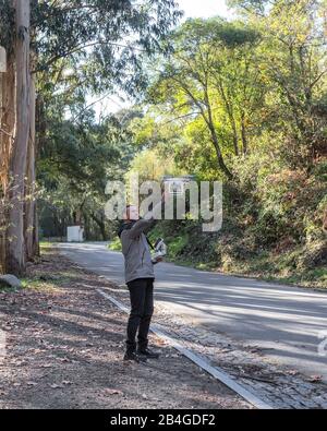 Der Mann steuert die Drohne zum Schießen. Im Wald. Stockfoto