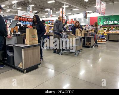 Orlando, FL/USA-12/14/19: Mitarbeiter von Lebensmittelgeschäften, die Lebensmittel an den Check-out-Stationen in einem Lebensmittelgeschäft in Orlando, Florida scannen. Stockfoto