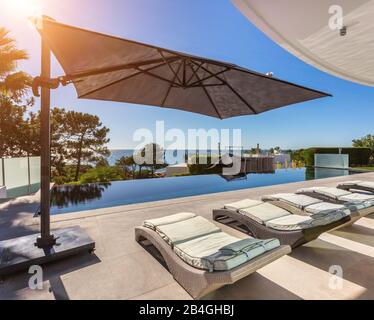 Herrliche Aussicht vom Pool auf die Sonnenliegen. In einem Luxushotel Stockfoto