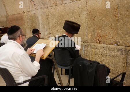 Juden, die während des Sabbats in der westlichen Mauer beten. Westliche Mauer in der Altstadt von Jerusalem, ein Ort des Betens und Pilgerns, der dem jüdischen Volk heilig ist. Es sind die einzigen Überreste des Zweiten Tempels von Jerusalem, der von den alten Juden als einzigartig heilig gehalten und 70 n. Chr. von den Römern zerstört wurde. Die Echtheit der westlichen Mauer wurde von Tradion, Geschichte und archäologischen Forschungen bestätigt; die Mauer stammt etwa aus dem 2. Jahrhundert v. Chr. Stockfoto