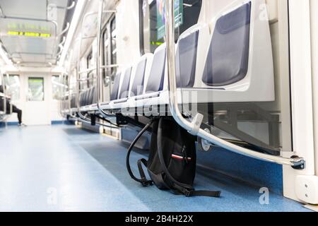 Vergessene schwarze Lederrucksack/Tasche oder Bombe für einen Terroranschlag liegt unter dem Sitz im U-Bahn-Zug, öffentliche Verkehrsmittel. Terrorgefahr. Stockfoto
