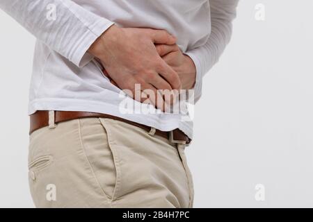 Studio Portrait des Mannes mit einem Stomachache nach dem Essen ungesunder fetthaltiger Lebensmittel, Krämpfe, isoliert auf weißem Hintergrund. Chronische Gastritis, schmerzende Bauchmuskeln. Stockfoto