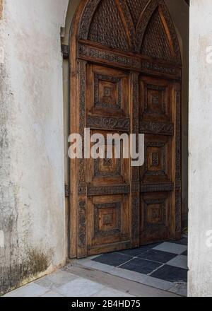 Tansania, Insel Sansibar: Anglikanische Kirche in der Steinstadt, die auf dem Gelände des alten Sklavenmarktes errichtet wurde, als Mahnmal gegen den Handel mit Sklaven. Holztür, Eingang zur Kirche. Stockfoto