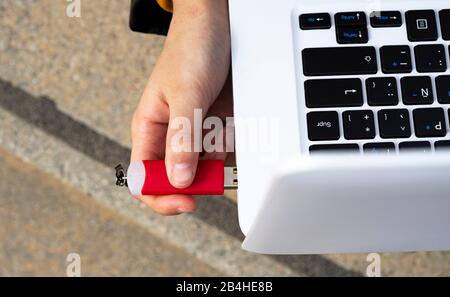 Verbinden Sie eine Pendrive mit dem Laptop per Hand. USB-Konzept. Stockfoto