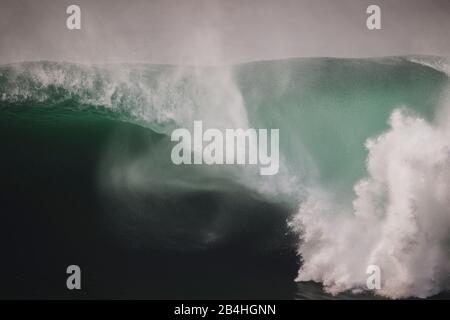 Massive Welle spuckt ein riesiges Fass unter den Klippen von Moher, Irland Stockfoto