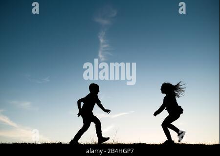 Silhouetted Kinder laufen zusammen in Waco Texas Stockfoto