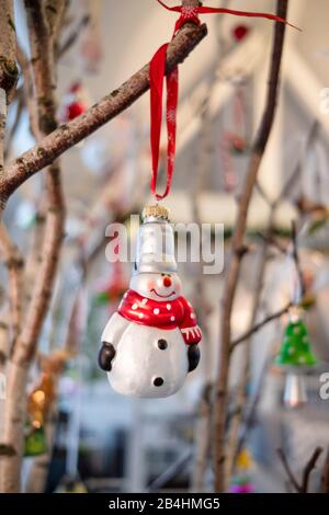 Stimmungsvoller Weihnachtsschmuck, Glaskugel, Schneemann mit Schal an Birkenzweig Stockfoto