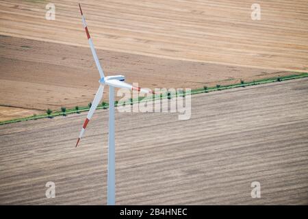 Lufttaufnahme eines Windrades auf landwirtsschützten Feldern und Äckern Stockfoto