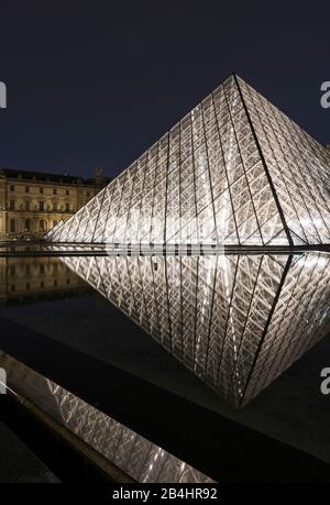 Die nächtliche Glaspyramide im Louvre spiegelte sich im Wasser, in Paris, Frankreich und Europa wider Stockfoto