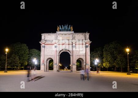 Touristen am Nachts beleuchteter Arc de Triomphe du Carrousel mit Quadriga am Louvre, Paris, Frankreich, Europa Stockfoto