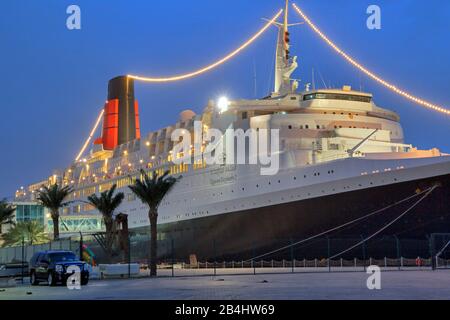 Beleuchtete Hotel- und Museumsschiff Queen Elizabeth 2 (QE2) am Pier in der Dämmerung, Dubai, Persischer Golf, Vereinigte Arabische Emirate Stockfoto