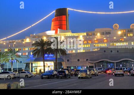 Beleuchtete Hotel- und Museumsschiff Queen Elizabeth 2 (QE2) am Pier in der Dämmerung, Dubai, Persischer Golf, Vereinigte Arabische Emirate Stockfoto