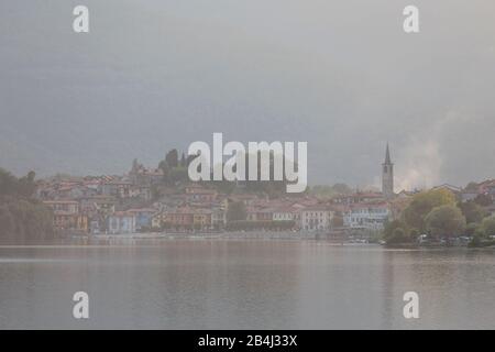 Europa, Italien, Piemont, Mergozzo. Abendlicker Blick über den Lago di Mergozzo auf die Uferpromenade mit dem Turm der Pfarrkirche Chiesa di Maria Ver Stockfoto