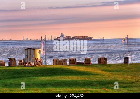 Gras-Strand mit liegen am Wattenmeer und Containerschiff in der Abendsonne, Nordseebad Wremen, Land Wursten, Wesermündungsgebiet, Nordsee, Nordseeküste, Nationalpark Niedersachsen-Wattenmeer, Niedersachsen, Deutschland Stockfoto