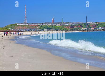 Nordstrand an der Badedüne mit Strandwanderern gegen die Hauptinsel Helgoland, Helgoland-Bucht, Deutsche Bucht, Nordseeinsel, Nordsee, Schleswig-Holstein, Deutschland Stockfoto