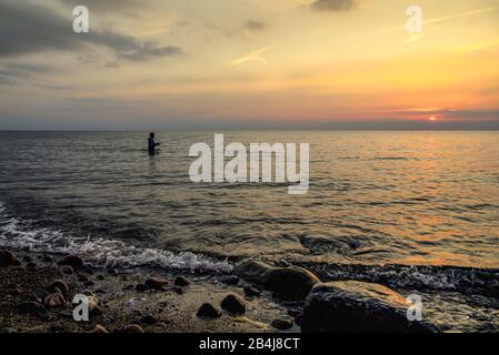 Angler in der Ostsee stehen bei Sonnenuntergang auf der Klippe zwischen Ahrenshoop und Wustrow Stockfoto