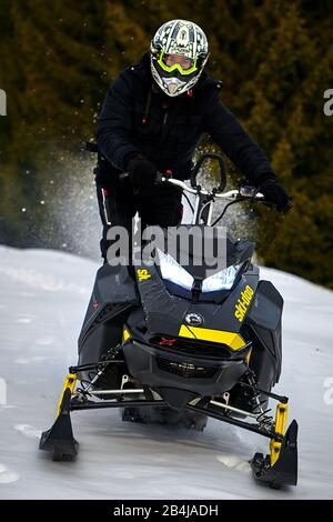 Tusnad, RUMÄNIEN - 02. Februar 2019: Ein Mann fährt mit Schneemobilen in den Bergen, Und Der Mann fährt mit Schneemobilen in TUSNAD, RUMÄNIEN Stockfoto