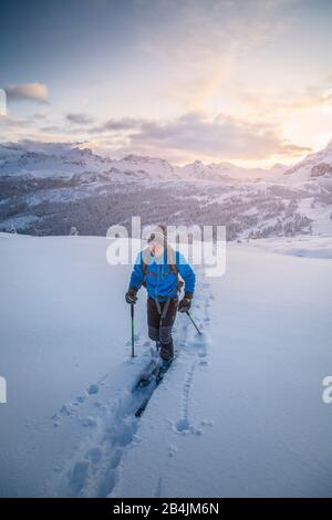 20 Jahre junger Skibergsteiger folgt bei Sonnenuntergang einem Pfad im Neuschnee, Pralongia-Hochebene, Corvara in Badia, Badia-Tal, Südtirol, Italien, Europa Stockfoto