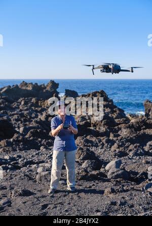 Frau kontrolliert Drohne im Flug, Quadrocopter, Lanzarote, Kanarische Inseln, Spanien Stockfoto