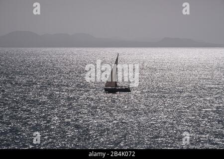 Segelboot auf dem Meer mit Hintergrundbeleuchtung, Lanzarote, Kanarische Inseln, Spanien Stockfoto