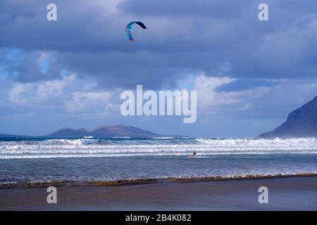 Kitesurfer, Playa de Famara in Caleta de Famara, hinter der Insel La Graciosa, Kanarische Inseln, Spanien Stockfoto