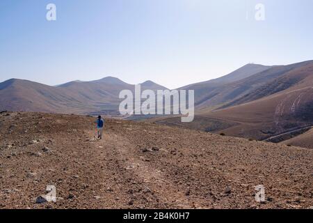 Frau läuft auf dem Kraterrand der Caldera Gritana, in Yaiza, Region La Geria, Lanzarote, Kanarische Inseln, Spanien Stockfoto