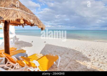 Sonnenschirm aus Kokospalmenhalm und liegen am weißen Strand an der karibischen Küste der Riviera Maya, Cancun, Mexiko. Stockfoto