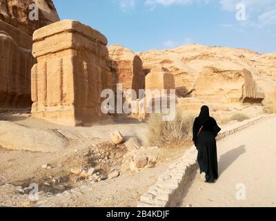 Jordan, Petra, eine Frau spaziert am Tempel aus Sandstein der historischen Felsenstadt Petra vorbei. Stockfoto