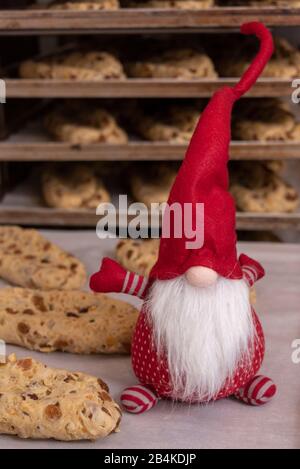 Weihnachtsmann aus Tuch, steht auf Backblech mit Weihnachtsstollen. Stockfoto