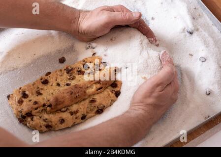 Baker würfelt Weihnachtskuchen in Zucker. Stockfoto