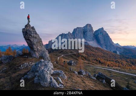 Einsamer Mann, der auf einem Felsen steht, der auf die Nordwand des Mount pelmo, der dolden, san vito di cadore, belluno, veneto, italien blickt Stockfoto