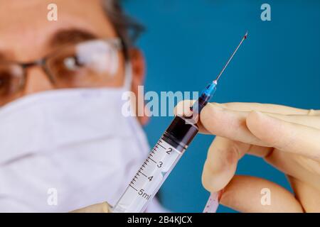 Bereiten Sie menschliches Blut auf eine Covid 19-Testinschrift mit einer Spritze und Blut im Inneren vor. Stockfoto