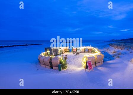 Deutschland, Mecklenburg-Vorpommern, Wustrow, Strandkörbe, Weihnachtsmarkt an der Strand, Tannengrün, blaue Stunde. Stockfoto