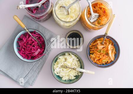 Weißkohl, Kimchi und Rotkohl gegoren, in konservierenden Gläsern eingepickt, in kleinen Schüsseln serviert Stockfoto