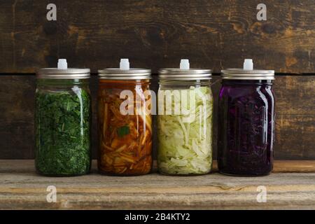 Weißkohl, Kimchi, Rotkohl und Kale fermentiert, in konservierenden Gläsern eingepickt Stockfoto