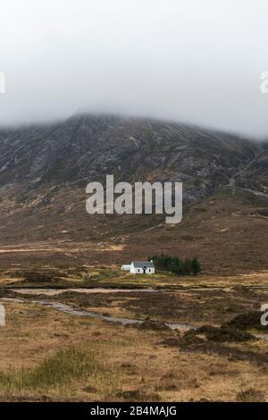 Großbritannien, Schottland, Highlands, Glencoe, White Cottage und Berge im Nebel Stockfoto