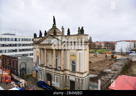 03. März 2020, Brandenburg, Potsdam: Hinter dem Portal der Garnisonkirche erstreckt sich ein abgeflachter sandiger Bereich. Links befindet sich das Gebäude des ehemaligen Rechenzentrums (DVZ) des Bezirks Potsdam und heute das Kunst- und Kreativhausrechenzentrum der Stiftung Sozialpädagogisches Institut Berlin (SPI). Die Kirche wurde in den Jahren von 1730 bis 1735 nach den Plänen des Architekten Philipp Gerlach erbaut und galt als ein Hauptwerk des preussischen Barock. Nach der Bombardierung durch die Alliierten am 14. April 1945 blieben nur noch Ruinen übrig, die erst 1968 gesprengt und abgetragen wurden. Das Recon Stockfoto