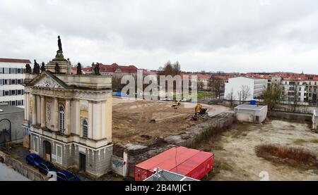 03. März 2020, Brandenburg, Potsdam: Hinter dem Portal der Garnisonkirche erstreckt sich ein abgeflachter sandiger Bereich. Links befindet sich das Gebäude des ehemaligen Rechenzentrums (DVZ) des Bezirks Potsdam und heute das Kunst- und Kreativhausrechenzentrum der Stiftung Sozialpädagogisches Institut Berlin (SPI). Die Kirche wurde in den Jahren von 1730 bis 1735 nach den Plänen des Architekten Philipp Gerlach erbaut und galt als ein Hauptwerk des preussischen Barock. Nach der Bombardierung durch die Alliierten am 14. April 1945 blieben nur noch Ruinen übrig, die erst 1968 gesprengt und abgetragen wurden. Das Recon Stockfoto